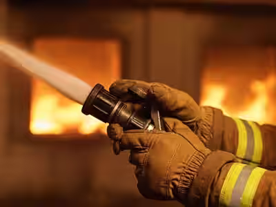 Guantes de bombero NFPA 1970 en operación de combate de incendio con manguera